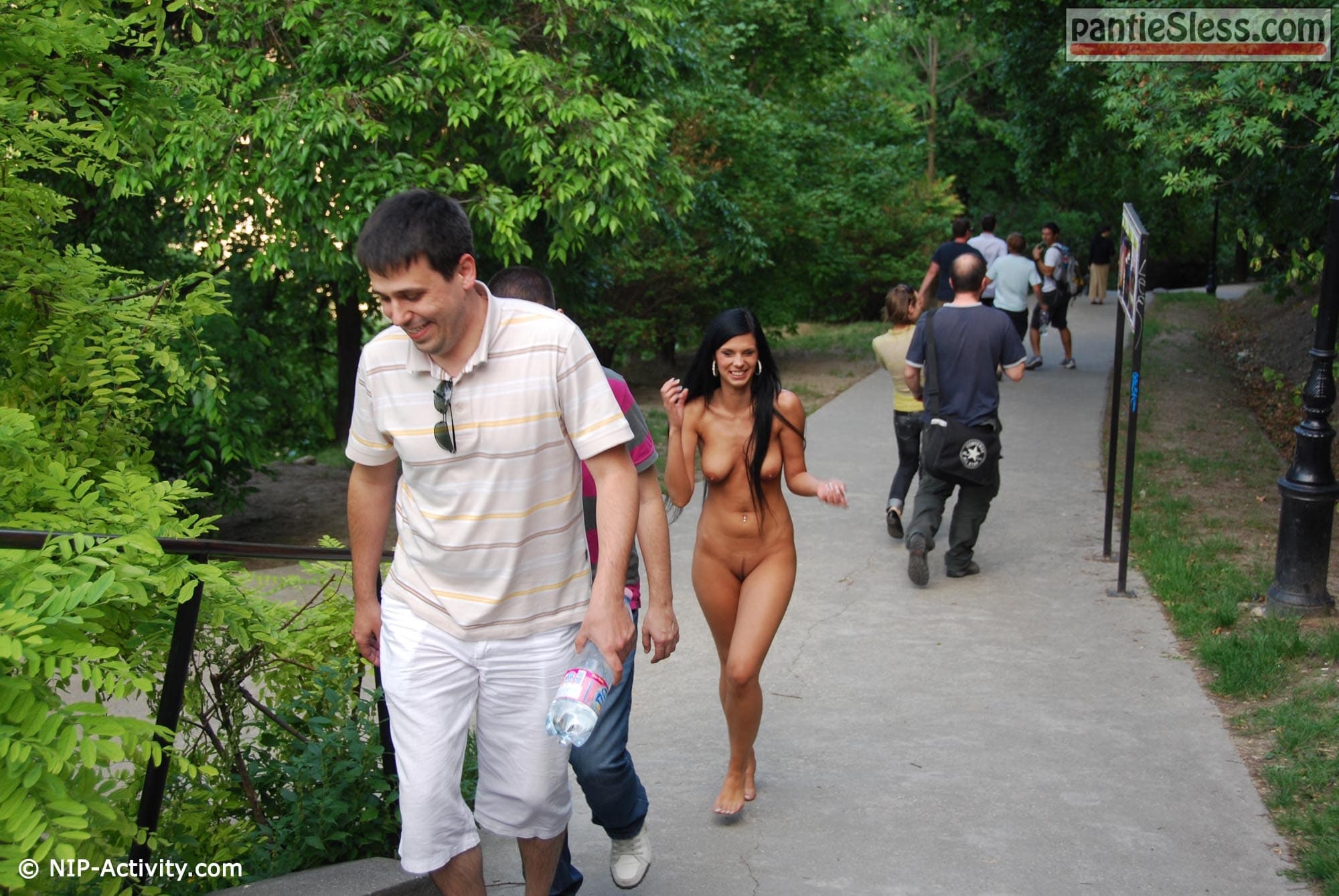 Dark haired fully nude goddess passing by tourists