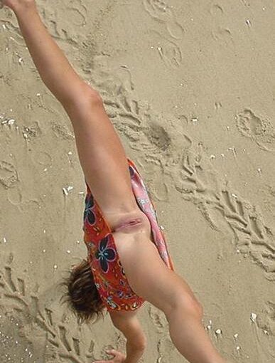 Babe flashing her shaved pussy on beach