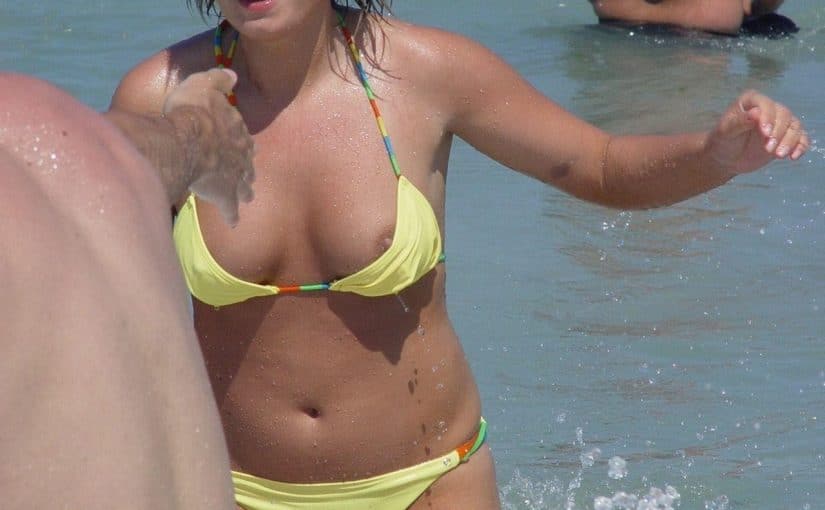 Hot babe having nip slip moment at beach